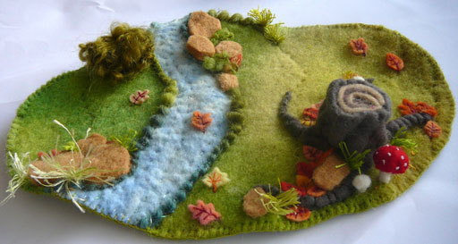 Stitched from wool felt small scene of tree stump,fallen leaves and stream