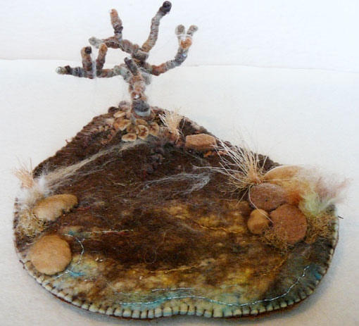 Bare tree made from wire and wool set in a frosty winter landscape made from wool felt